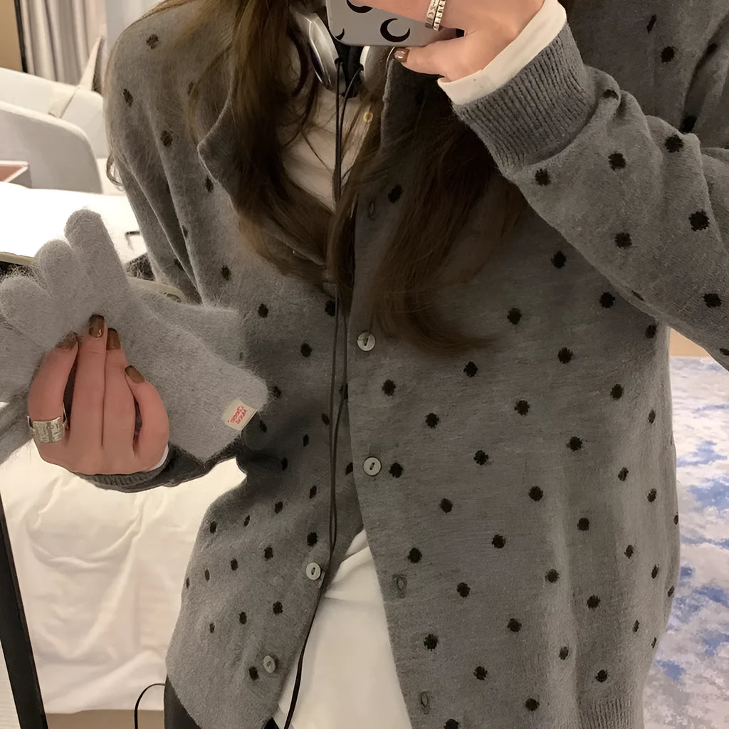 Women's loose fit grey dot knitted cardigan with crocheted flower trim on long sleeves.
