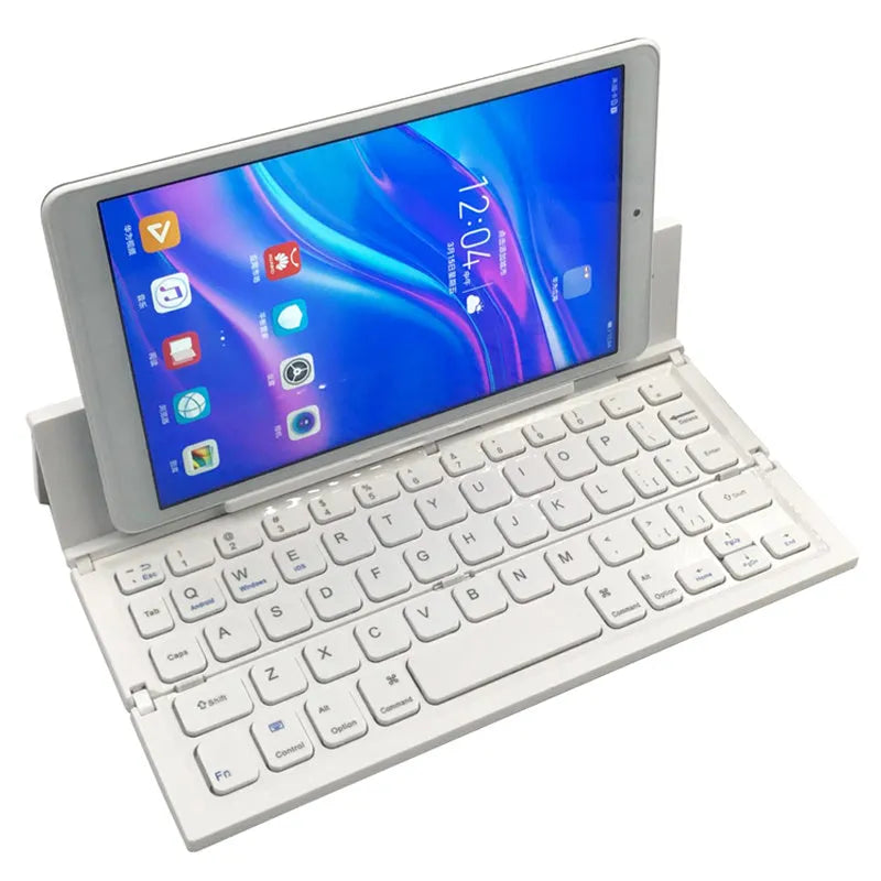 Black folding Bluetooth keyboard unfolded next to tablet showing ultra-thin design