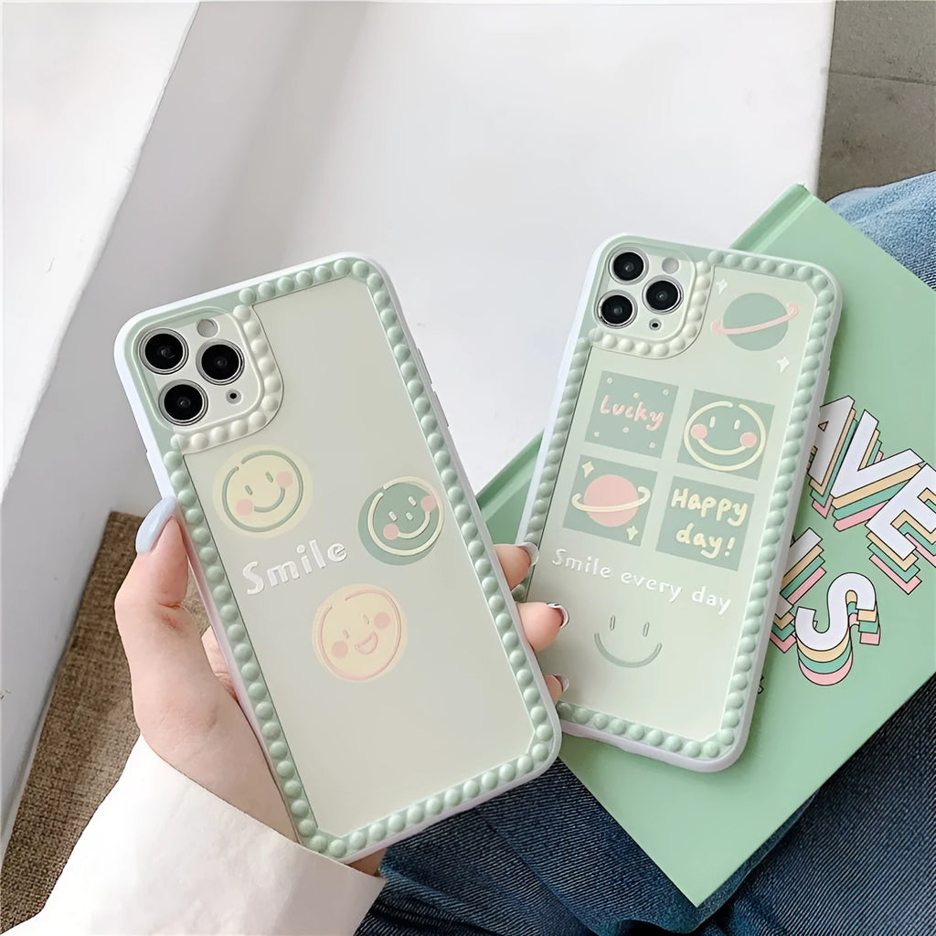 Green iPhone case with geometric smiley face design and polka dot frame on a TPU back cover.