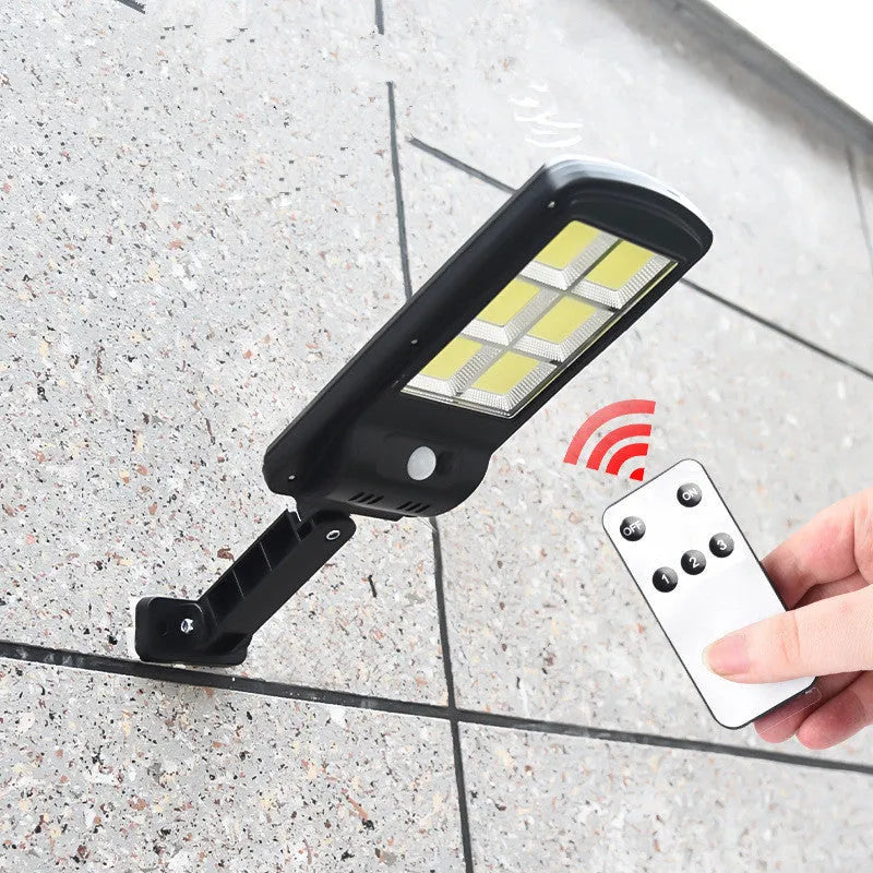 Black solar motion sensor light for outdoor garden and security lighting with PIR detection
