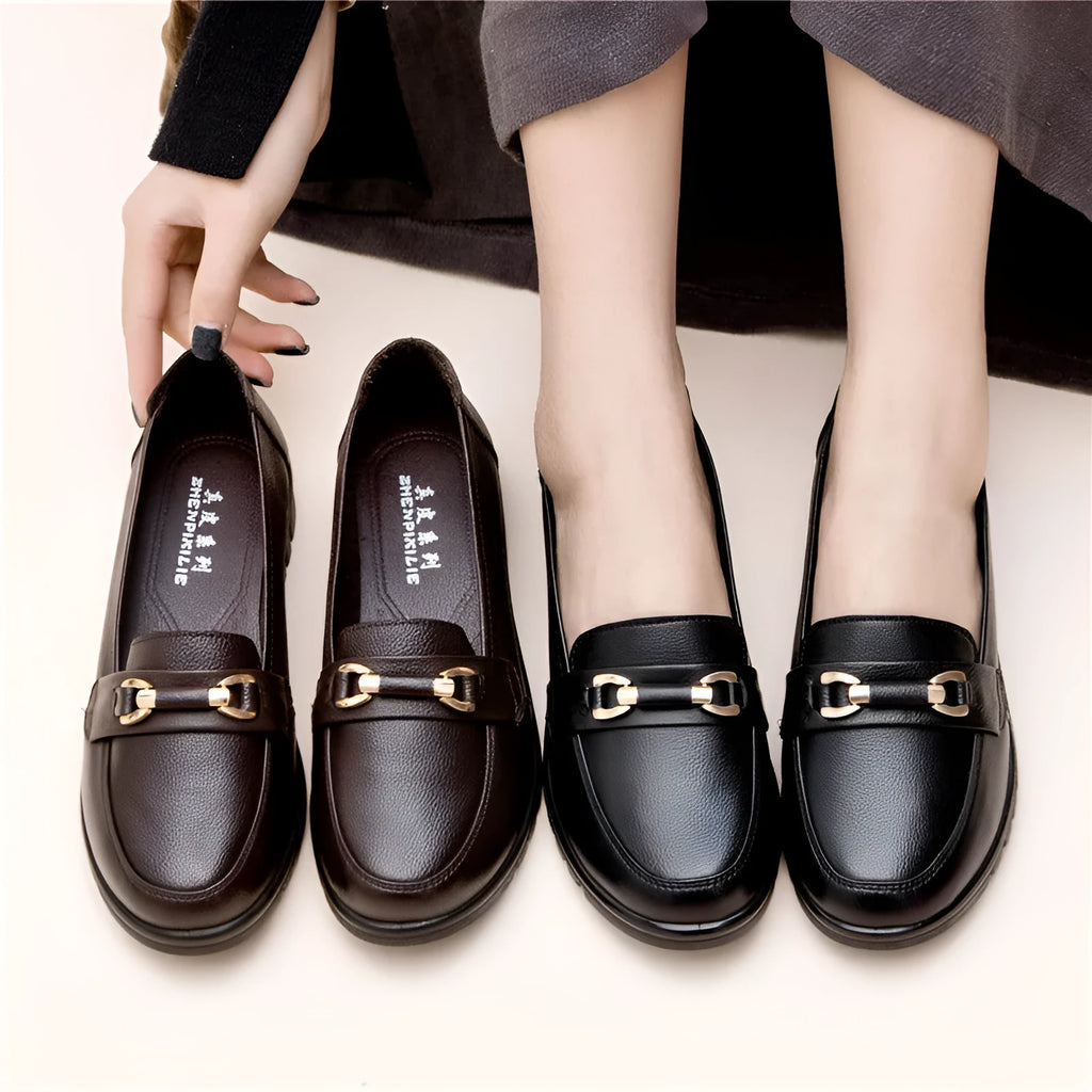 Black soft leather women's pumps with a round toe, low flat heel, and rubber sole.