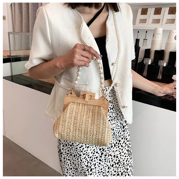 Women's straw shoulder bag with pearl chain detail and multiple zipper compartments in neutral colour