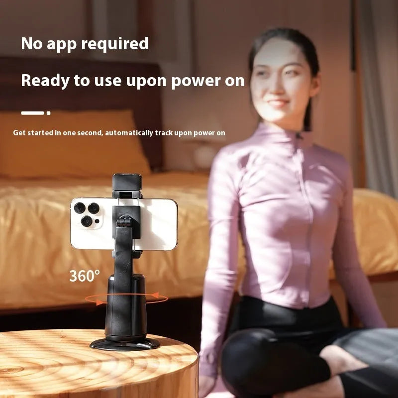 Black intelligent face tracking mobile phone holder with rotating camera head and ribbon lighting on desktop