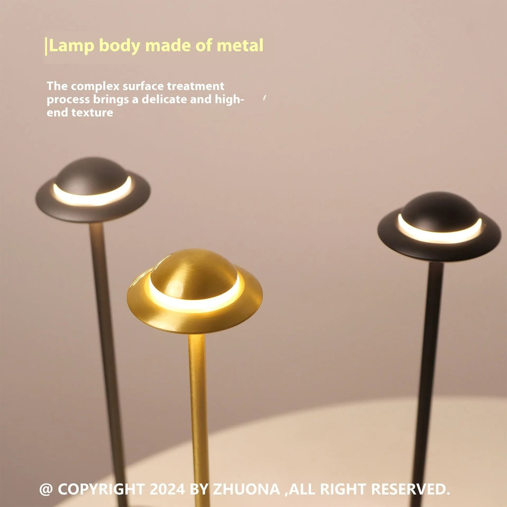 Metallic gold UFO-shaped table lamp with touch dimming on a wooden desk.