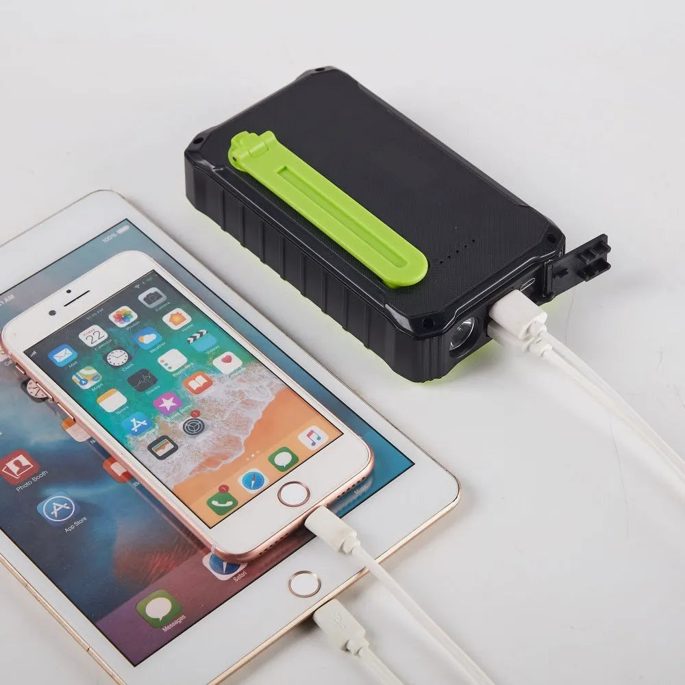 Orange and green solar hand power bank with 12000mAh capacity showing dual USB ports and hand crank