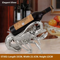 Lobster-shaped wine rack ornament in metallic rose gold or silver finish on display surface