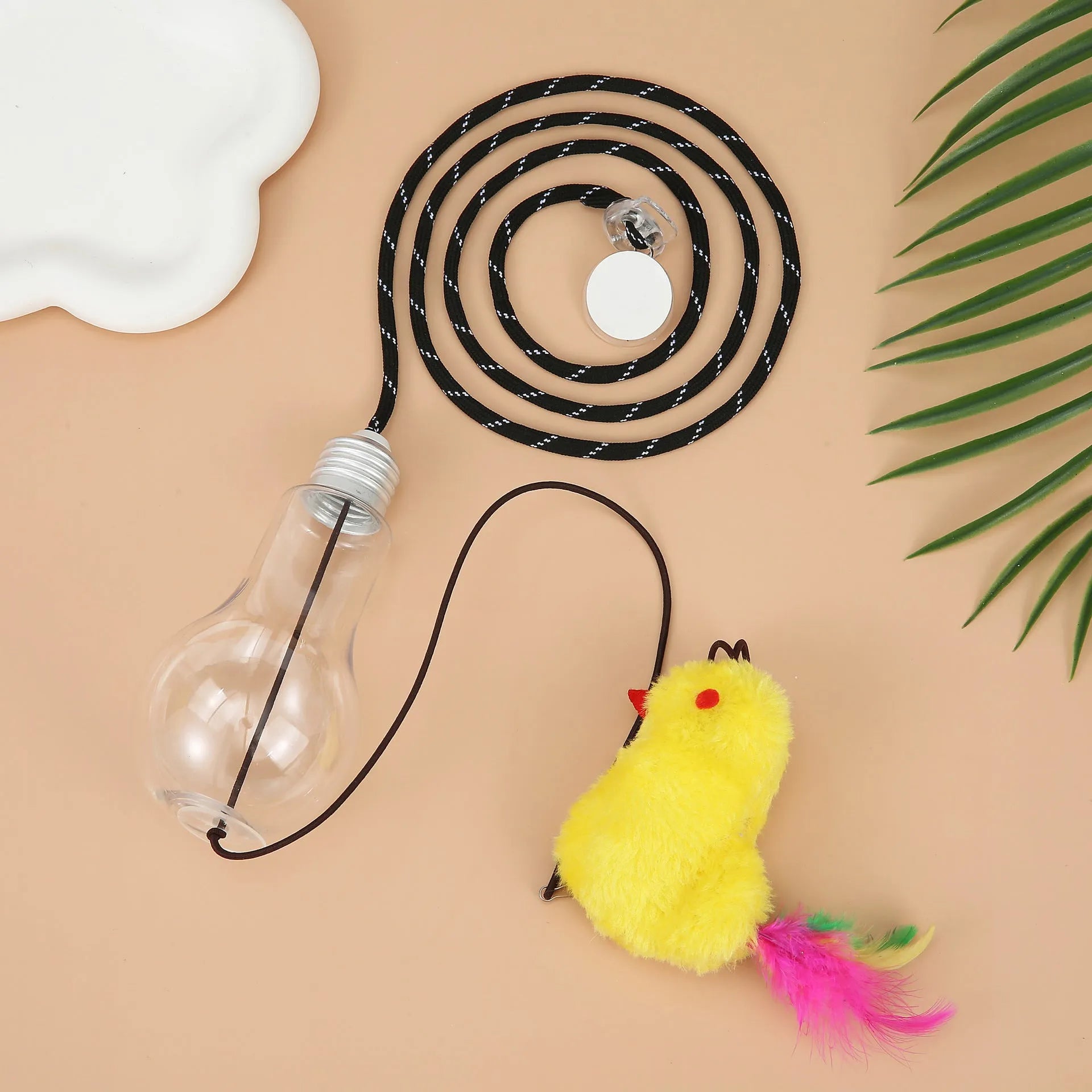 Grey and yellow retractable cat teaser toy hanging on door frame with treat bulb and dangling mouse