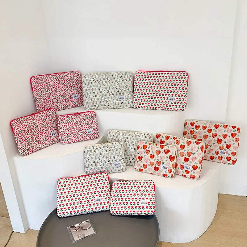 Green floral print cloth laptop bag shown next to red heart and pink floral design options.