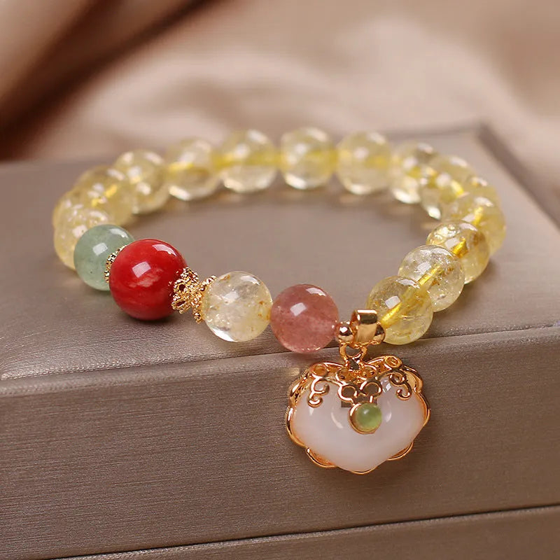 Women's yellow alloy bracelet with a ruyi pendant charm holding natural citrine and yellow hair crystal jade.