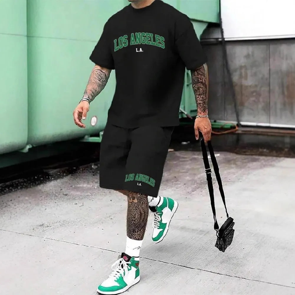 Man wearing a grey 3D printed letter design short sleeve top and matching shorts sports set.