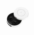 Mini black semi-in-ear wireless headphones placed inside their white wireless charging case, shown open.