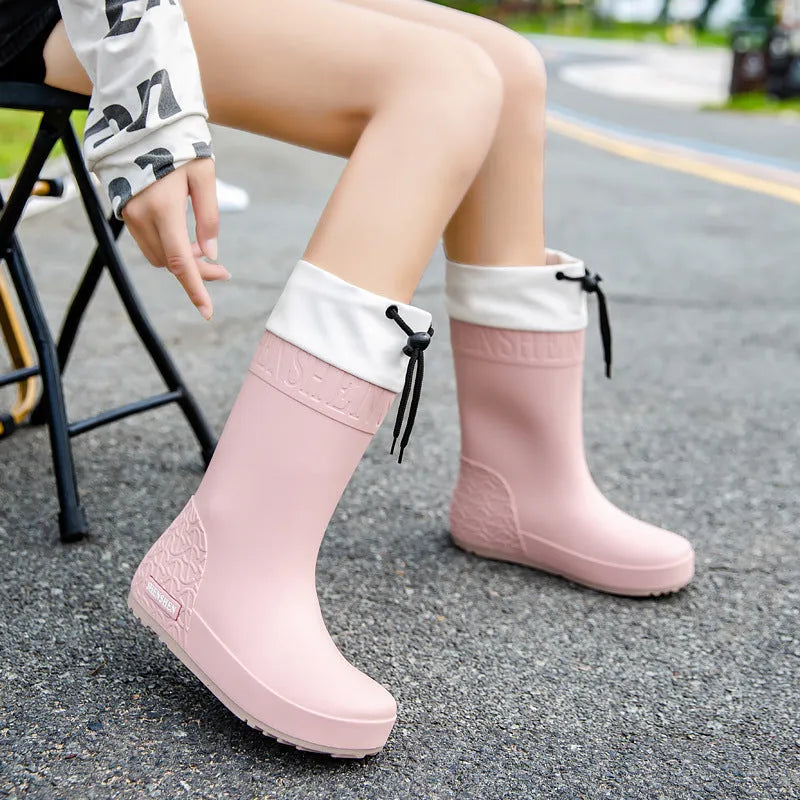 Women's solid colour PVC rain boots in apricot, black, brown, or pink.