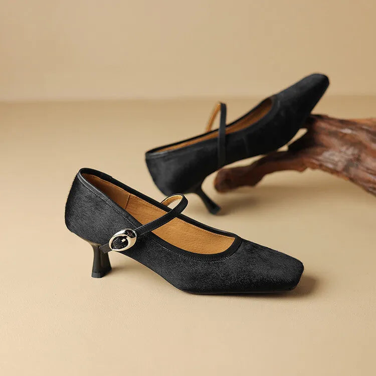 Women's black square toe ankle-strap stiletto heels with horse hair upper on wooden surface
