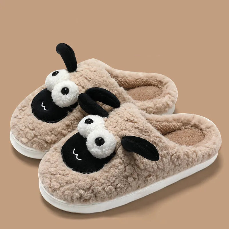 Brown suede slip-on slippers with a light-coloured sewn PVC sole on a wooden floor.