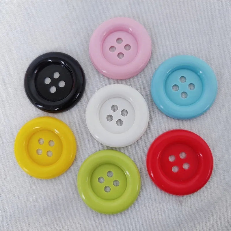 Assortment of large round plastic sewing buttons in multiple colours with four holes.