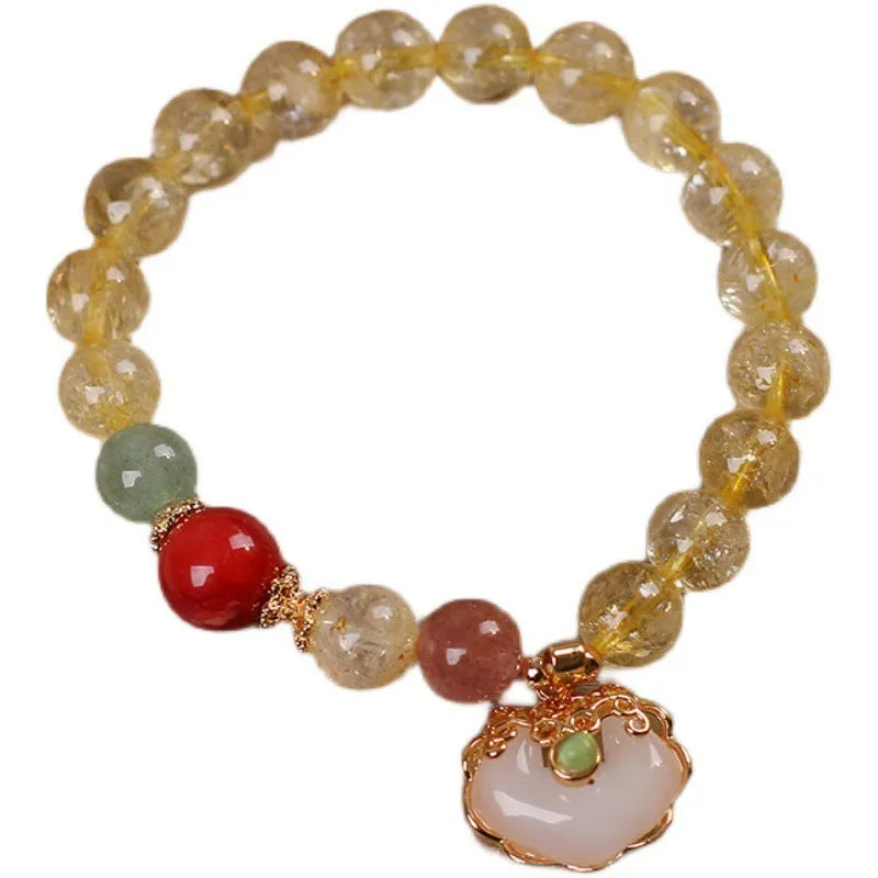 Women's yellow alloy bracelet with a ruyi pendant charm holding natural citrine and yellow hair crystal jade.