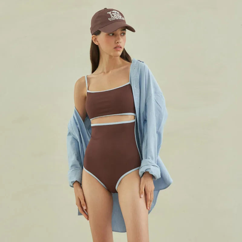 Brown women's triangle one-piece swimsuit on a hanger.
