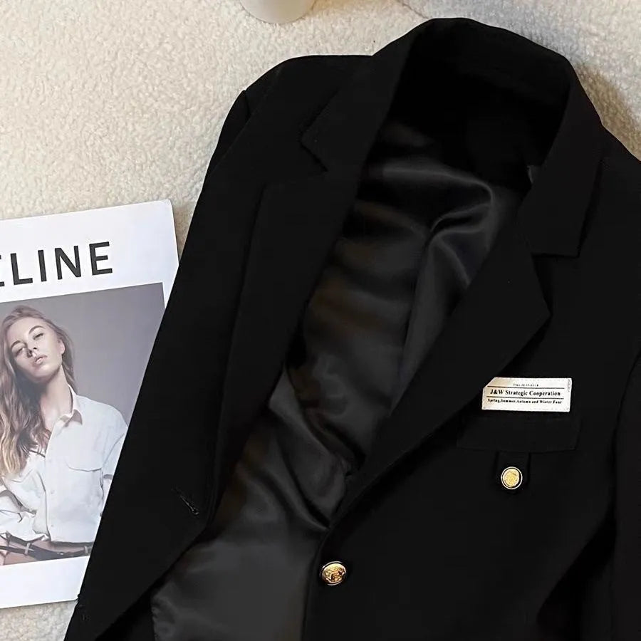 Black women's short suit coat with pockets, loose fit, and regular long sleeves.