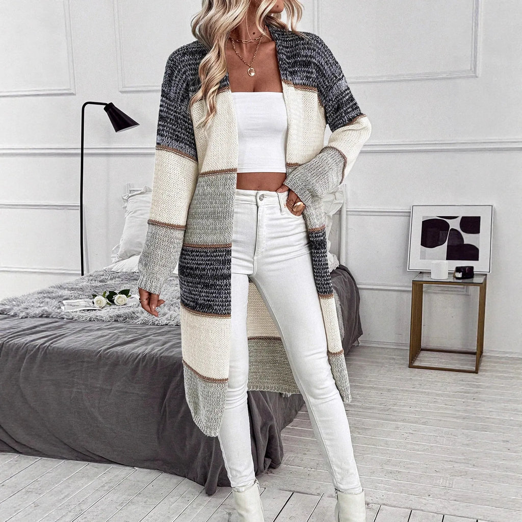 Grey striped women's long sleeve knitted cardigan on a hanger, showing loose fit.