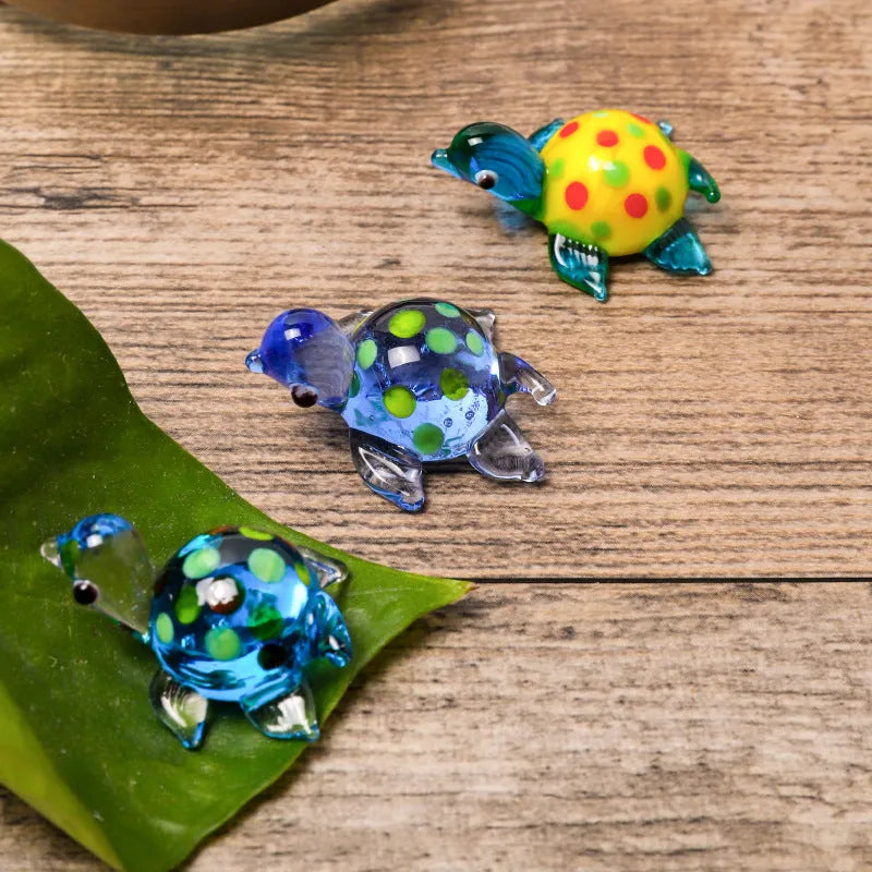 Glass geometric turtle ornament in blue head with blue shell colour variation on wooden desktop