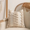 Knitted tassel pillow cover in striped pattern on a sofa.