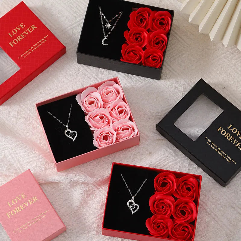 Korean style gift box open to show six red soap flowers, with a handbag beside it.