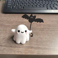 Miniature resin statue of a ghost walking a dog and holding a bat, a 4cm tall Halloween decoration.