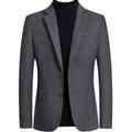 A man wearing a slim-fit grey wool blend suit jacket for autumn and winter leisure wear.