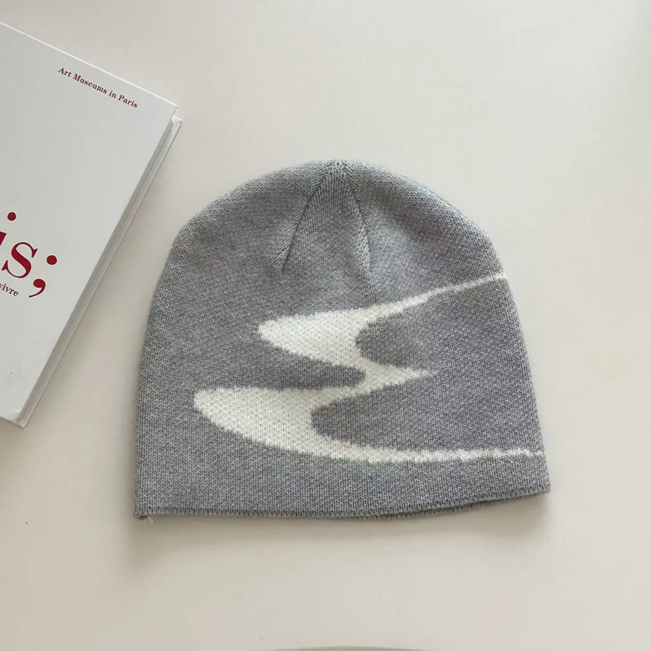 Acrylic knitted beanie hat in black, shown on a model, suitable for winter wear.