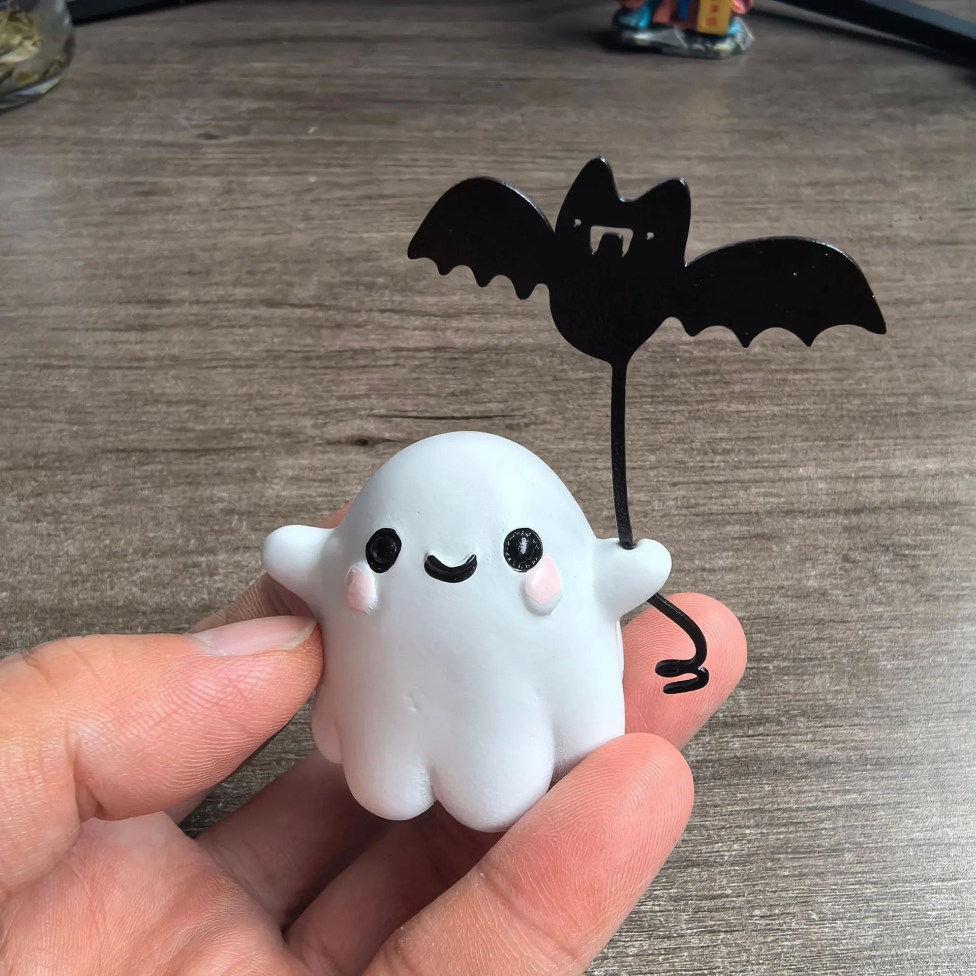 Miniature resin statue of a ghost walking a dog and holding a bat, a 4cm tall Halloween decoration.