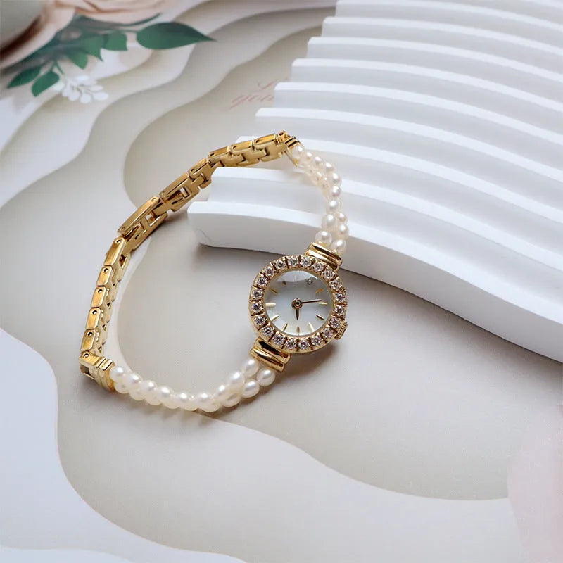 Women's light gold freshwater pearl bracelet watch with round dial on wrist