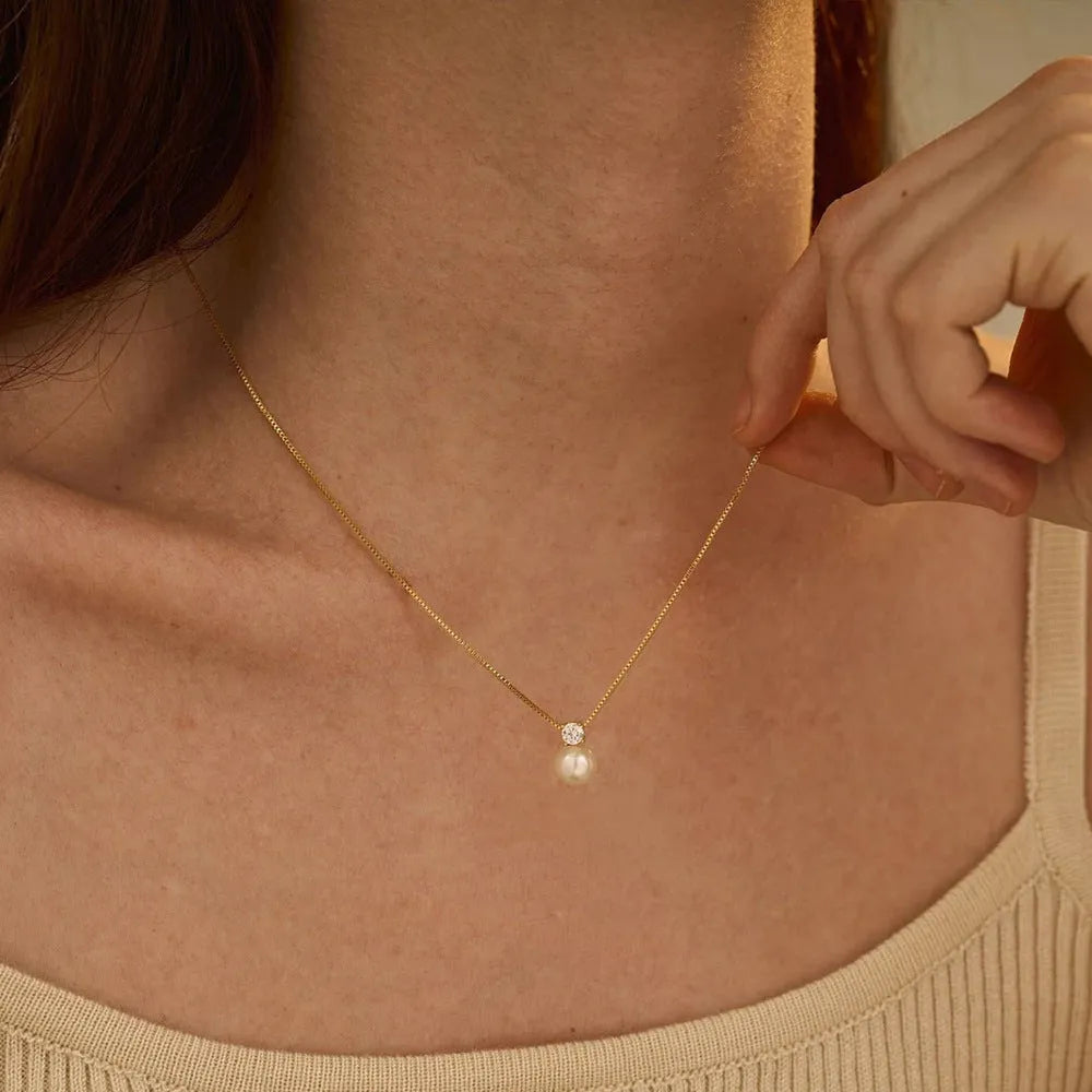 Gold and steel colour women's necklace with imitation pearl and zircon pendant on a stainless steel box chain.