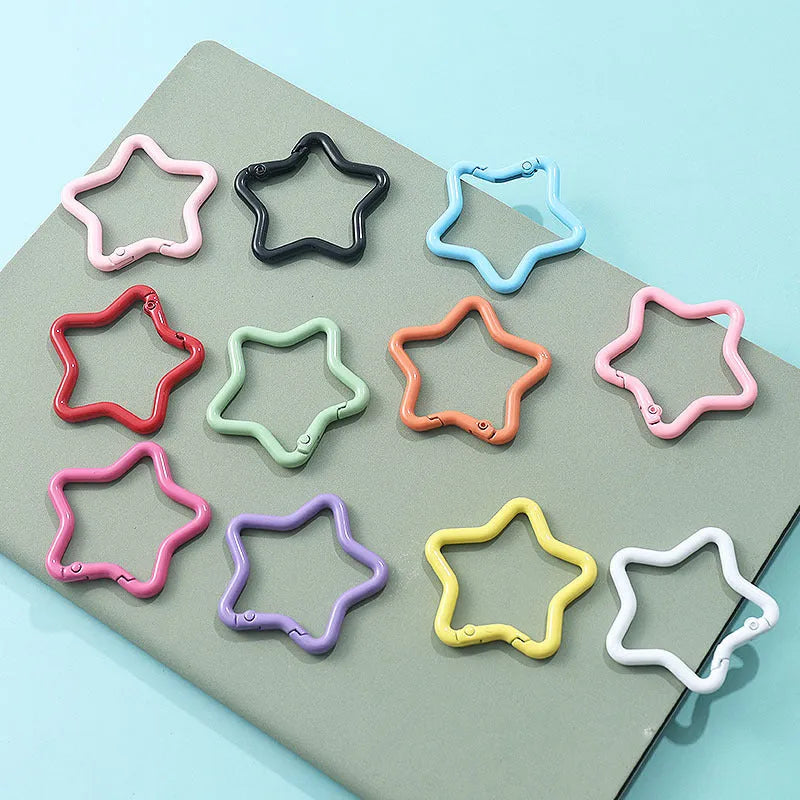 Zinc alloy five-pointed star keychain charm in assorted colours including light pink, blue, and black.