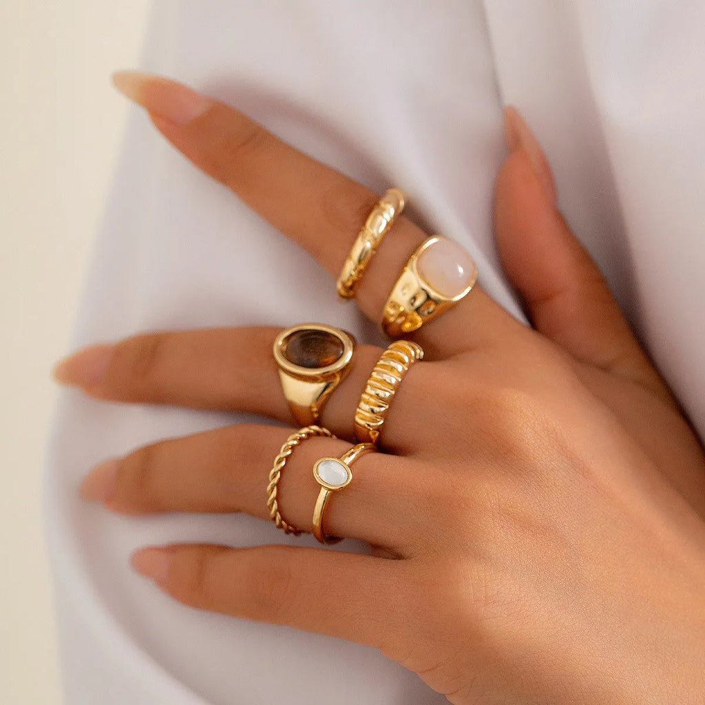Six geometric alloy rings with electroplated light gold finish displayed as a jewellery set