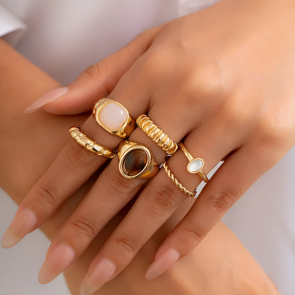 Six geometric alloy rings with electroplated light gold finish displayed as a jewellery set
