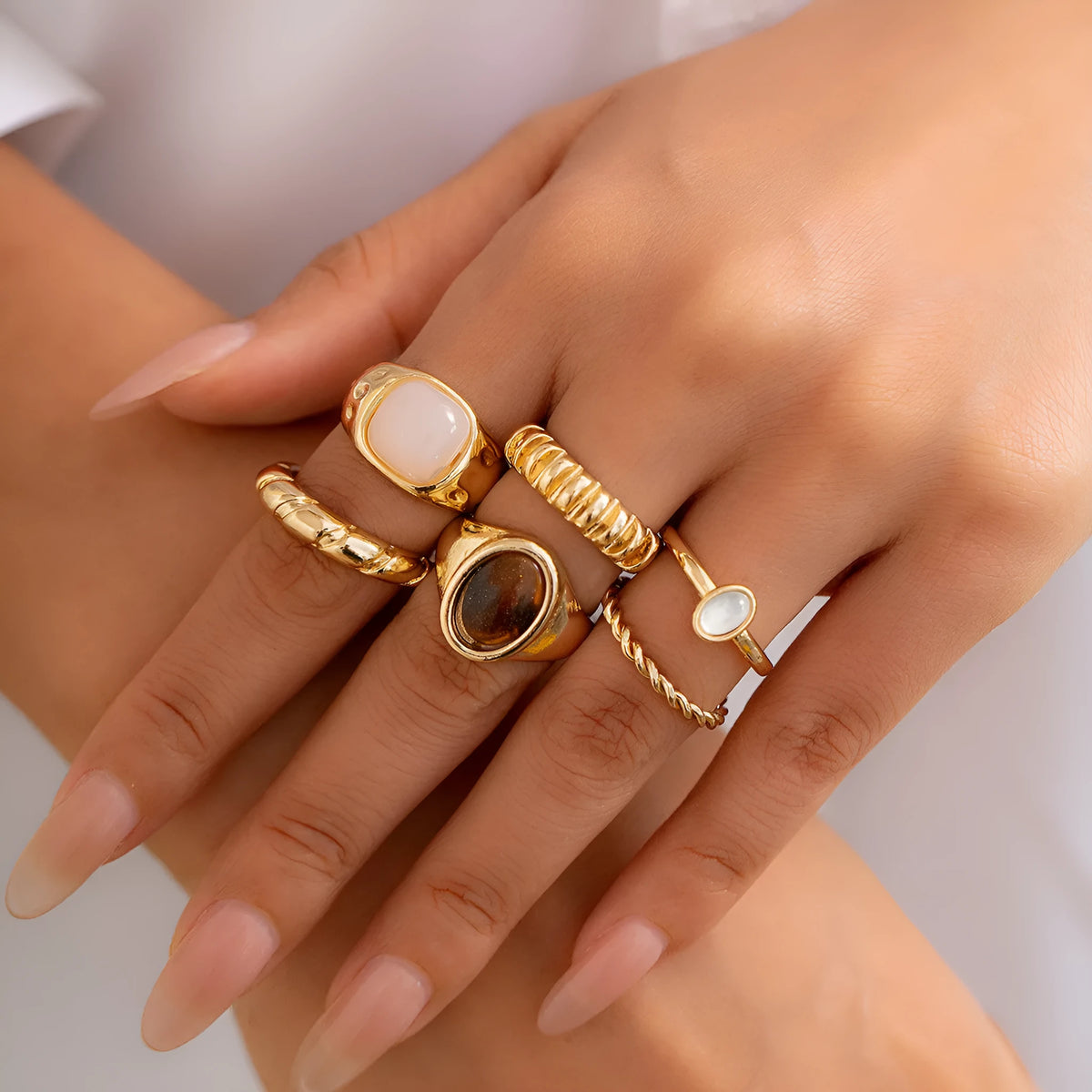Six geometric alloy rings with electroplated light gold finish displayed as a jewellery set