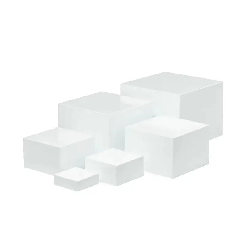 Set of six white plastic cube display stands arranged on a wooden tabletop.