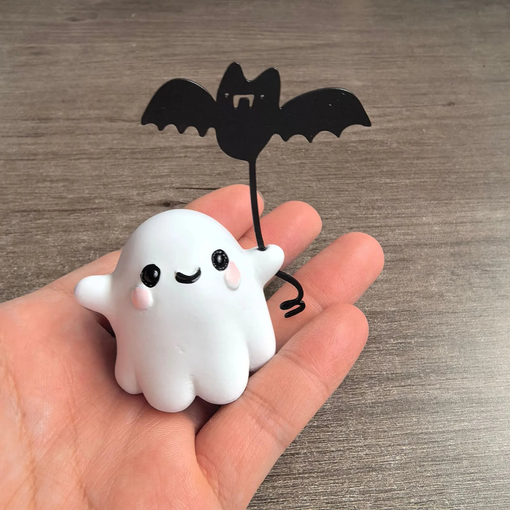Miniature resin statue of a ghost walking a dog and holding a bat, a 4cm tall Halloween decoration.