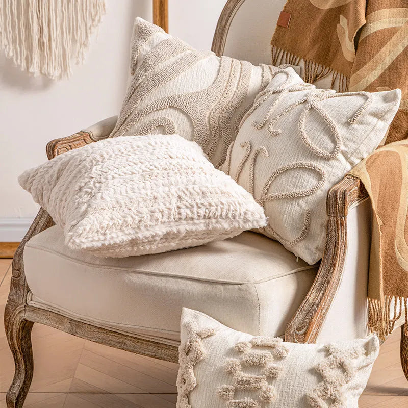 Knitted tassel pillow cover in striped pattern on a sofa.