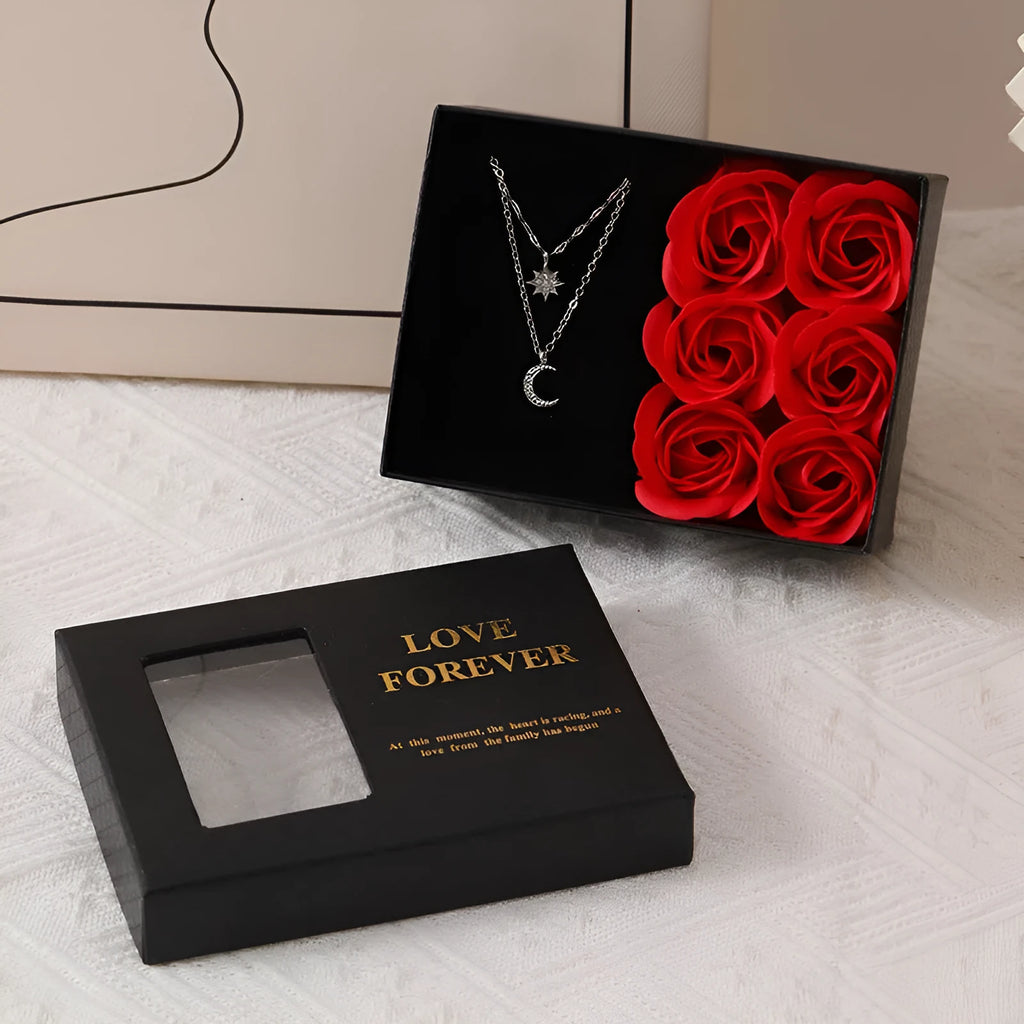 Korean style gift box open to show six red soap flowers, with a handbag beside it.