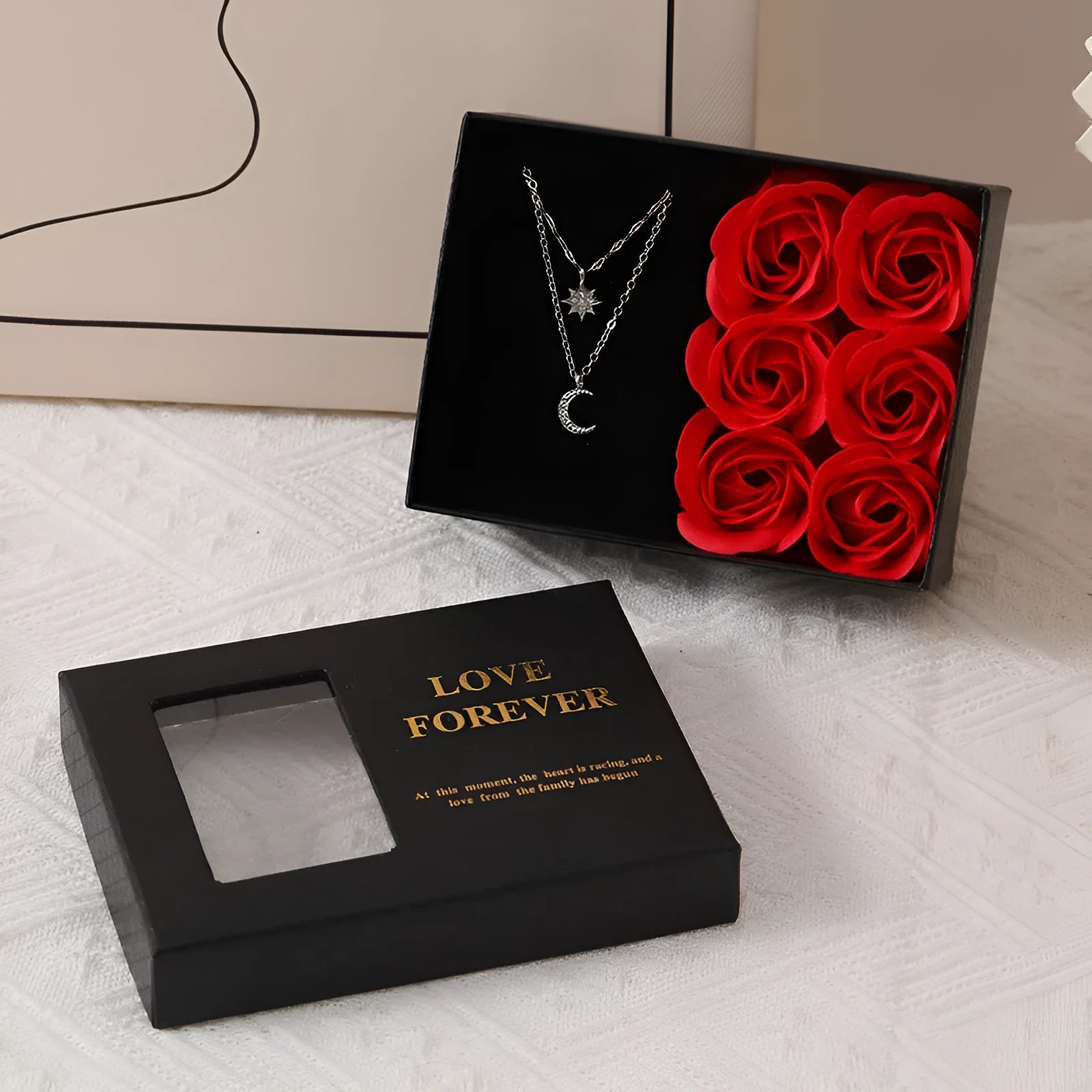 Korean style gift box open to show six red soap flowers, with a handbag beside it.