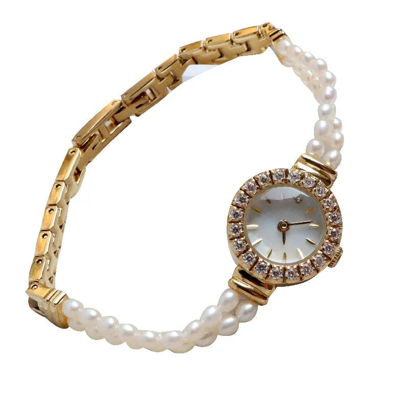 Women's light gold freshwater pearl bracelet watch with round dial on wrist