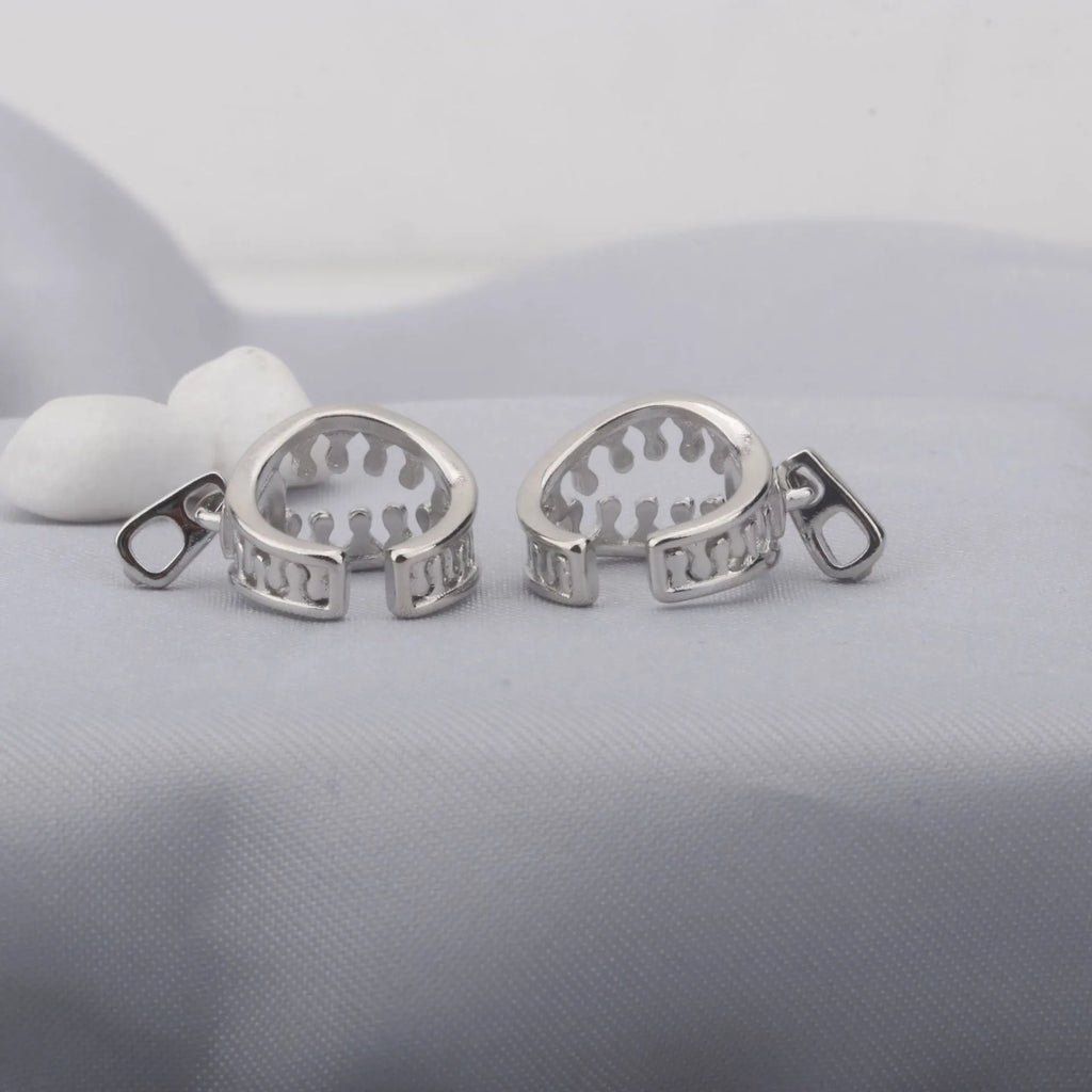 Copper geometric bone clip earrings with linear design on a white background.