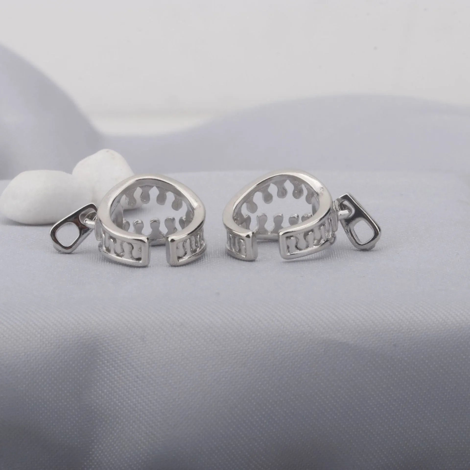 Copper geometric bone clip earrings with linear design on a white background.