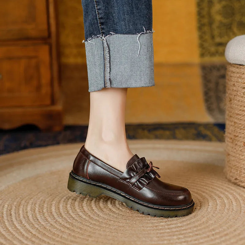 Women's black leather shoes with a chunky heel and round toe, showing the low-top design and cowhide upper.