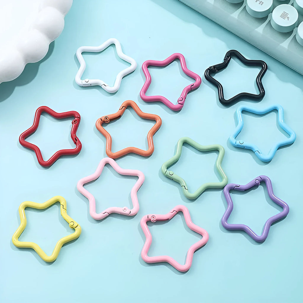 Zinc alloy five-pointed star keychain charm in assorted colours including light pink, blue, and black.