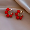 Red bell-shaped alloy drop earrings with gold-tone finish, approximately 2-3 cm length