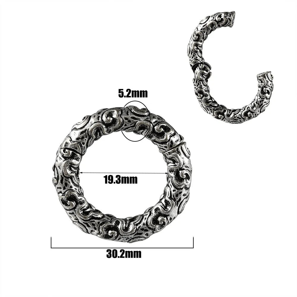A pair of stainless steel fashion earrings with an intricate totem pattern design in a silver-toned finish.