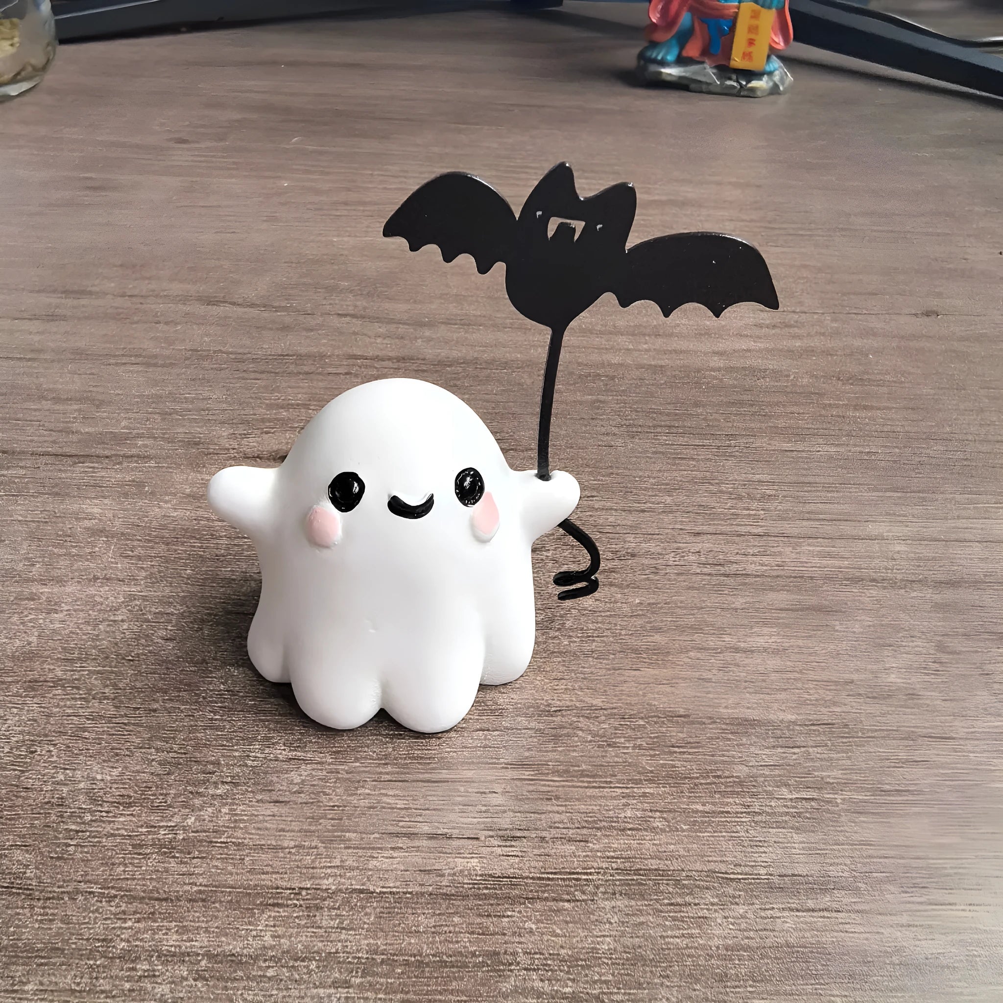 Miniature resin statue of a ghost walking a dog and holding a bat, a 4cm tall Halloween decoration.