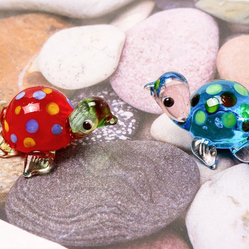 Glass geometric turtle ornament in blue head with blue shell colour variation on wooden desktop